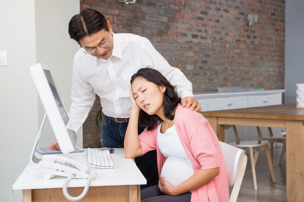 Marido consolando a su esposa embarazada sufriente en casa