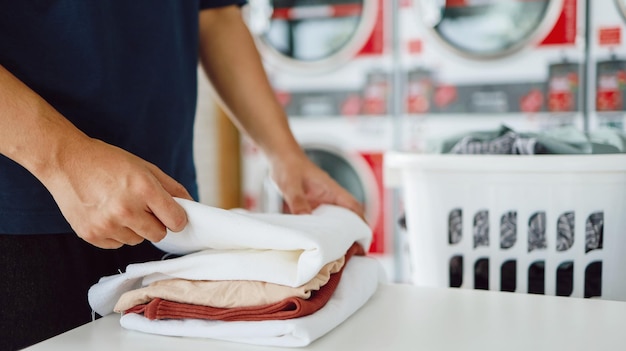Foto marido da casa com cesto e roupa suja lavada roupa na lavanderia interior da máquina de lavar na loja de negócios de lavanderia