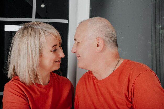 marido e mulher em camisetas laranja abraço e beijo