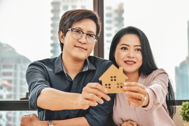 Marido e mulher estão comprando uma casa, Close-up mão segurando modelo de casa