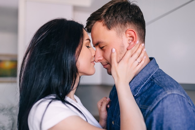 Marido e mulher fofos se abraçam ternamente em uma linda cozinha