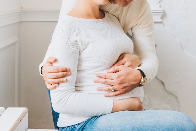 Marido e mulher grávida com as mãos na barriga