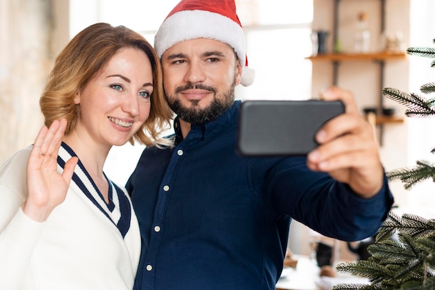 Marido e mulher tirando uma selfie juntos no Natal