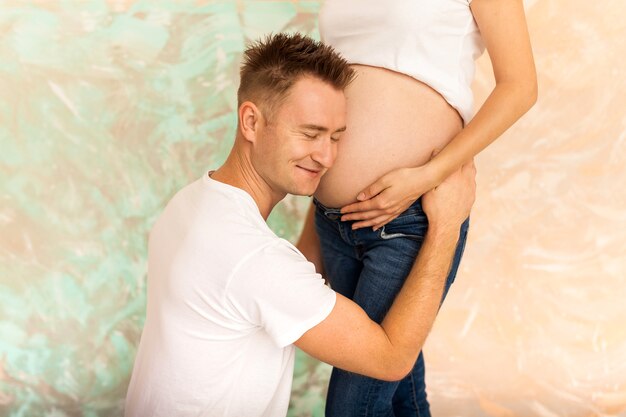 Marido escuchando el vientre de su esposa embarazada