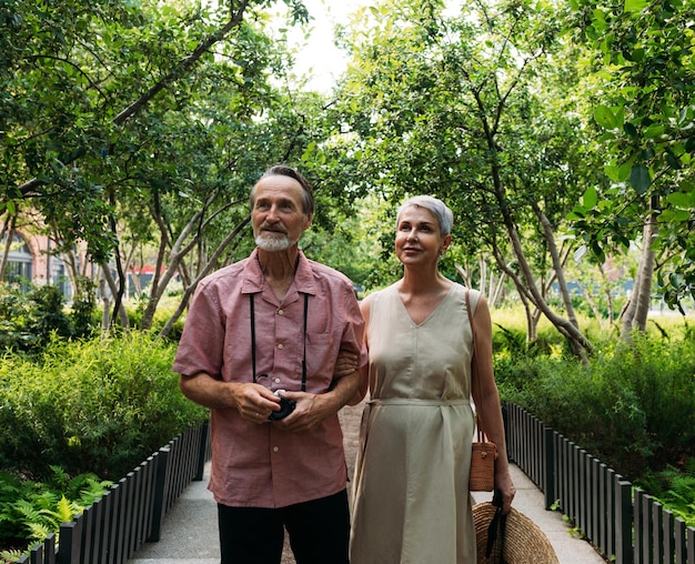 Un marido y una esposa ancianos caminando juntos en el parque.