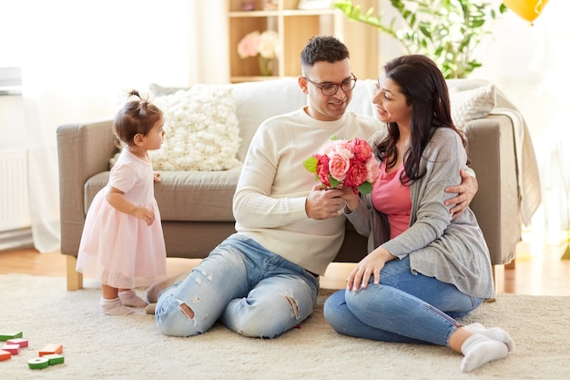 marido feliz dando flores a su esposa en casa