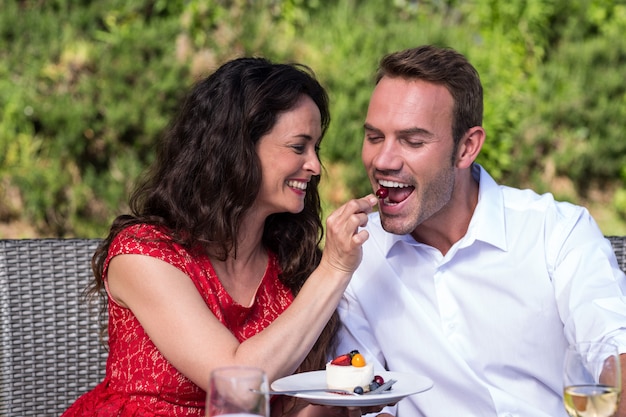 Marido feliz de alimentação da esposa no gramado