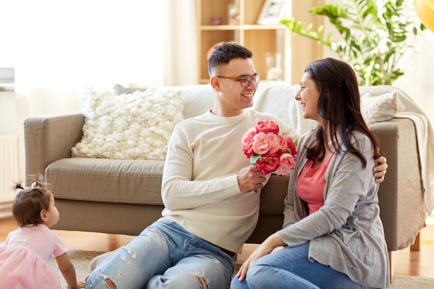 Foto marido feliz regalando flores a su esposa en casa