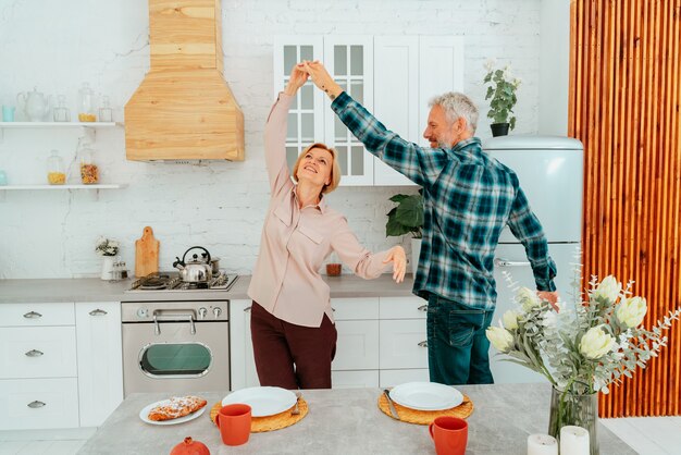 Marido y mujer bailan en casa durante el desayuno