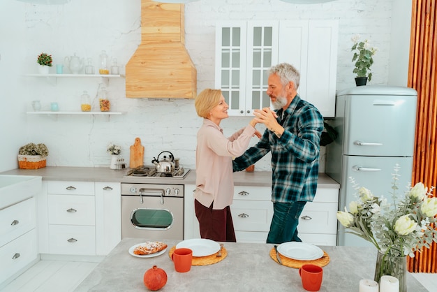 Marido y mujer bailan en casa durante el desayuno