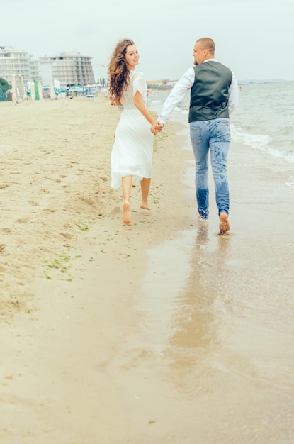 marido y mujer corriendo en la playa junto al mar