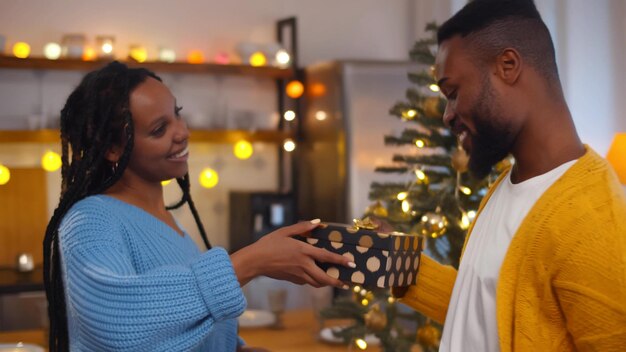 Marido y mujer intercambian cariñosamente regalos de Navidad