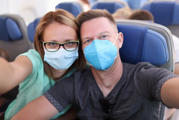 Marido y mujer toman selfie en avión con máscaras médicas