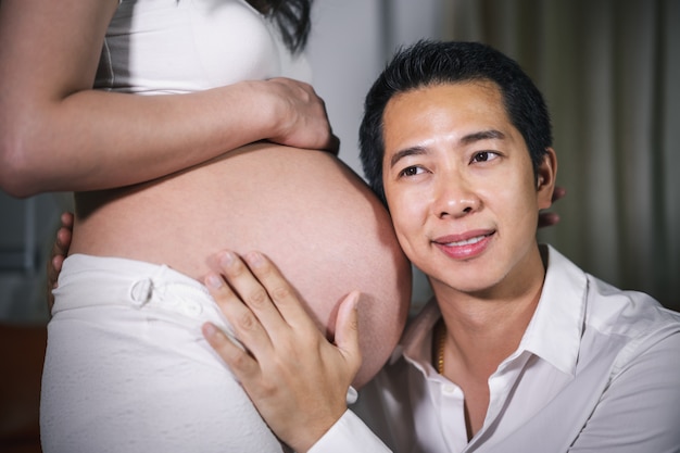 Marido, ouvindo a barriga da esposa