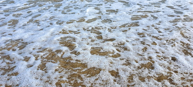 Marina. El color azul del agua, las olas espumosas en la orilla. Enfoque selectivo.