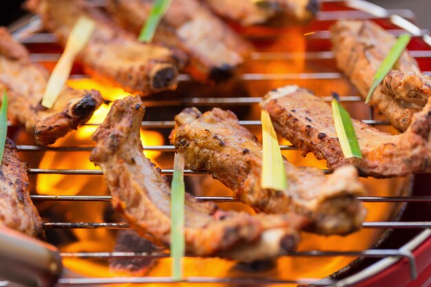 Marinado con salsa de barbacoa Costilla de cerdo de cerdo en la parrilla de carbón caliente.