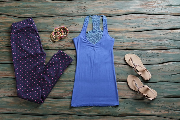 Marineblaue Hose und Tanktop. Sandalen und gepunktete Hosen. Frühlingsoutfit und Accessoires für Damen. Set aus kleinen bunten Armbändern.
