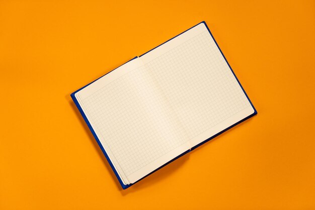 Marineblauer Notizblock mit weißen Laken auf orangefarbenem Sommerhintergrund Pläne für den Sommer To-do-Liste