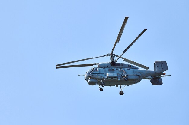 Marinehubschrauber, der gegen strahlend blauen Himmelshintergrund fliegt, Kopienraum. Ein militärischer U-Boot-Abwehrhubschrauber, der die U-Boot-Suche demonstriert, Seitenansicht