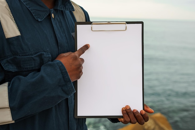 Foto marinheiro a bordo de um navio preenche a lista de verificação documentação no mar