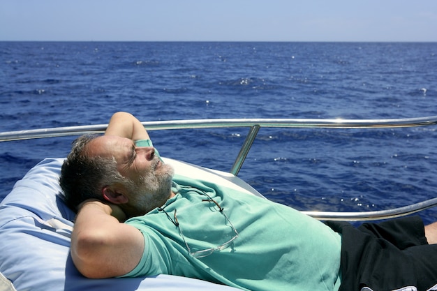 Marinheiro homem sênior descansando no barco de verão