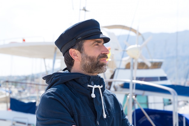 Marinheiro no porto de marina com fundo de barcos