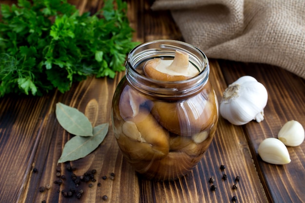 Marinierte Pilze shiitake im Glas auf der braunen rustikalen Holzoberfläche