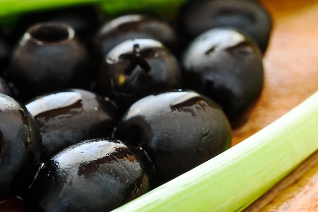 Marinierte schwarze Oliven auf Holzhintergrund