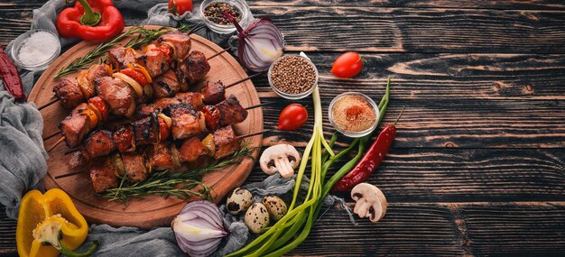 Marinierter gebackener Kebab mit Zwiebeln und Gewürzen Auf einem hölzernen Hintergrund Ansicht von oben Freier Platz für Text