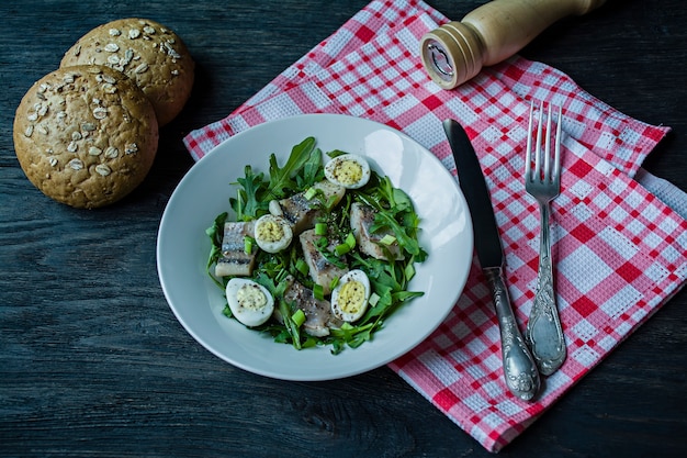 Marinierter Hering mit Rucola, Zwiebeln, gekochten Wachteleiern, Zitronensaft und Olivenöl.