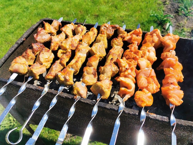 Foto marinierter schaschlik, der über kohlen außerhalb gekocht wird grill- und streetfood-konzept