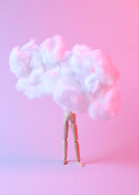 Marioneta de madera en una nube esponjosa flotante Luz degradada de neón rosa azul Idea creativa Arte conceptual Minimalismo Surrealismo