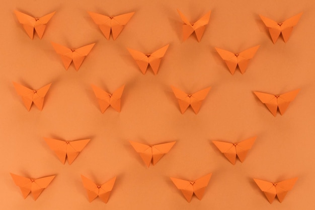 Mariposa de origami naranja sobre fondo naranja