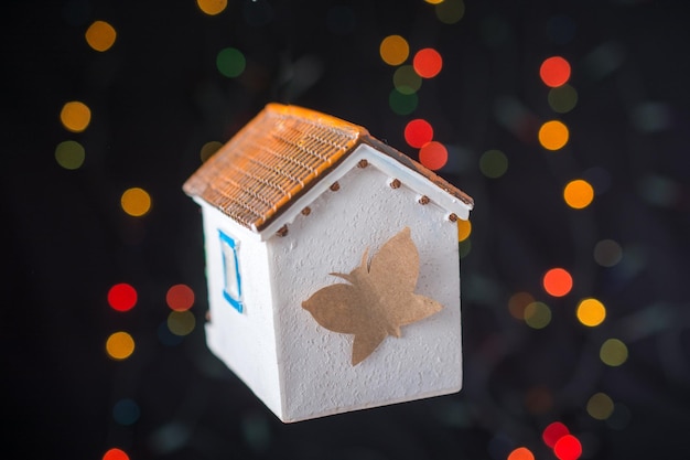 Mariposa de papel en una casa modelo en una luz bokeh