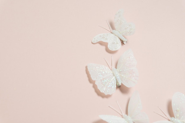 mariposas blancas hechas a mano sobre un banner de fondo rosa pálido espacio libre para texto