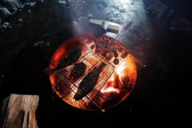 Marisco fresco a la parrilla con pescado en la barbacoa de noche