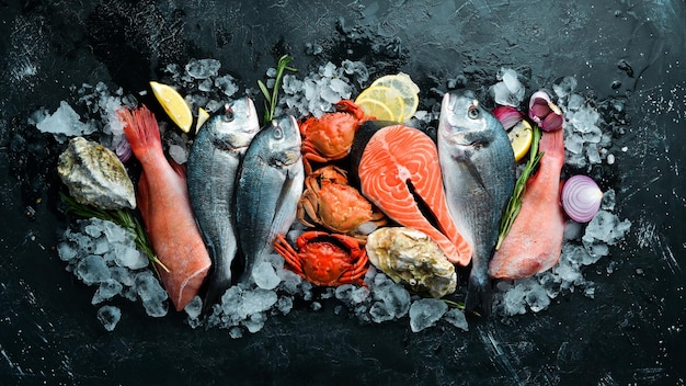 Mariscos Dorado salmón cangrejo mero ostras Sobre un fondo de piedra negra Vista superior Espacio libre para su texto