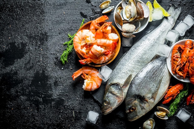 Foto mariscos pescado fresco con camarones, cigalas y ostras en un tablero de piedra