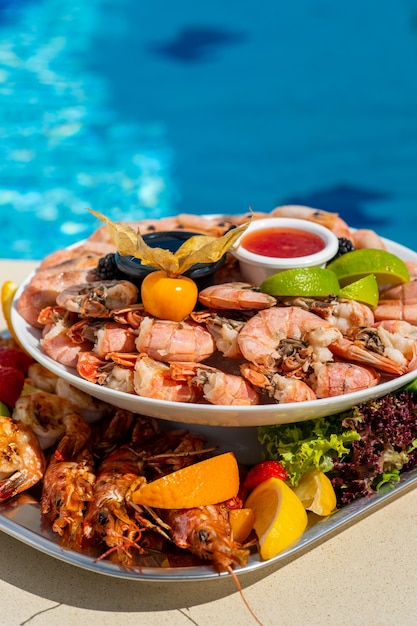 Mariscos en un resort de lujo con vista a la piscina Camarones, langosta, cangrejos, salsa de grulla de frutas