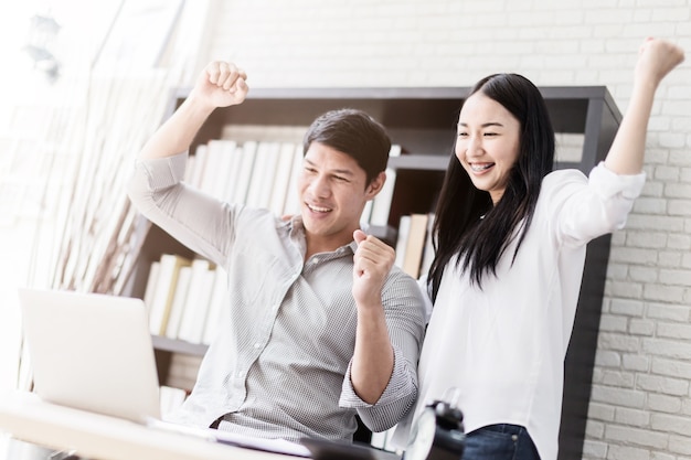 Marketing on-line de negócios com dois colegas de trabalho com caixa de produtos no fundo do escritório