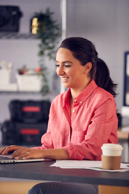 Marketing publicitario femenino o diseño creativo en estudio sentado en un escritorio trabajando en una computadora portátil