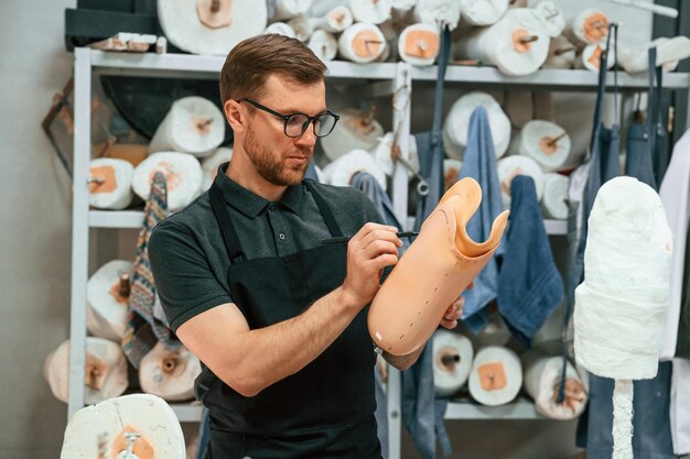 Foto markiert die linie mit einem marker techniker arbeitet mit prothese teil in einem modernen labor