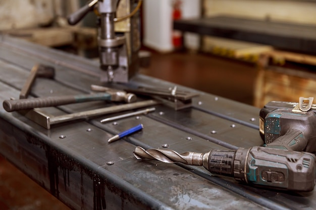 Markierung auf einer Metalloberfläche zum Bohren von Löchern mit einem Vierkant und einem Messschieber. Hammer, Nagelstanze.