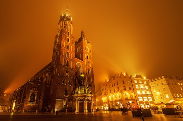 Marktplatz in Krakau bei nebliger Nacht mit der Marienkirche mit goldenem Himmel