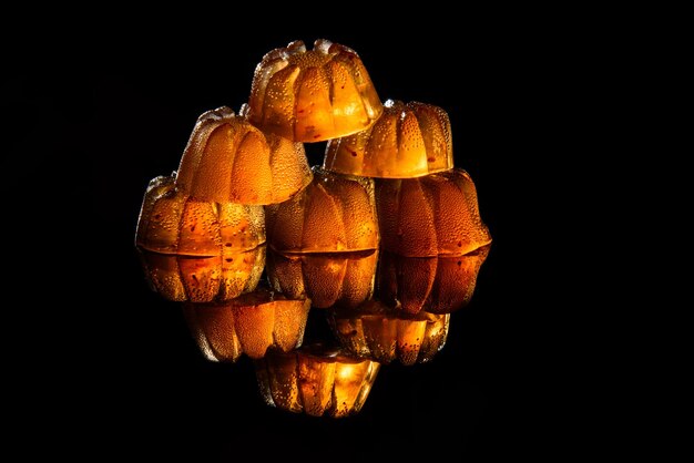 Marmelada de morango transparente em um fundo preto com reflexão.