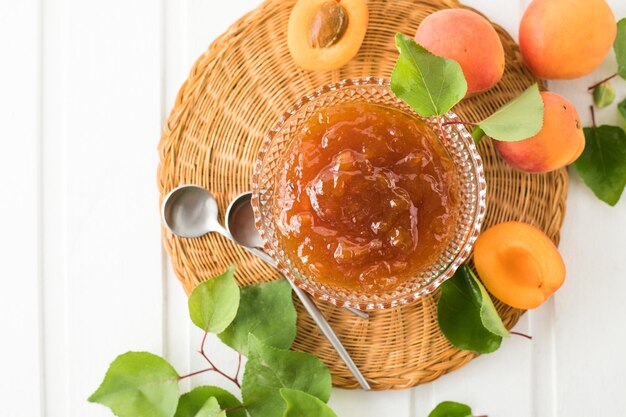 Marmelade aus Aprikosen und frischen Aprikosen Holzhintergrund