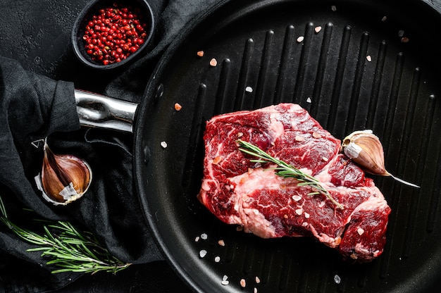 Marmoleado de carne en una sartén. Carne de granja ecológica. Fondo negro