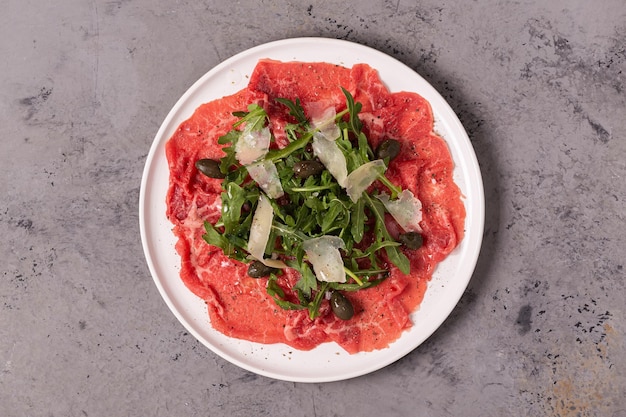 Marmoriertes Rindercarpaccio mit Rucola, Kapern und Parmesankäse