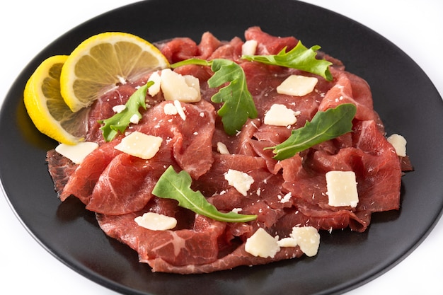 Marmoriertes Rindfleisch-Carpaccio auf schwarzem Teller isoliert