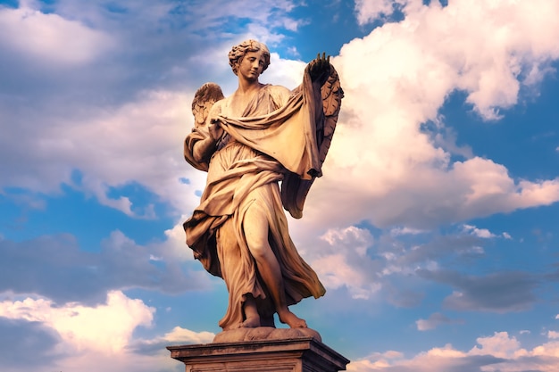 Foto marmorstatue des engels mit dem sudarium bei sonnenuntergang, einer der zehn engel auf der saint angel bridge, symbole der passion christi, rom, italien